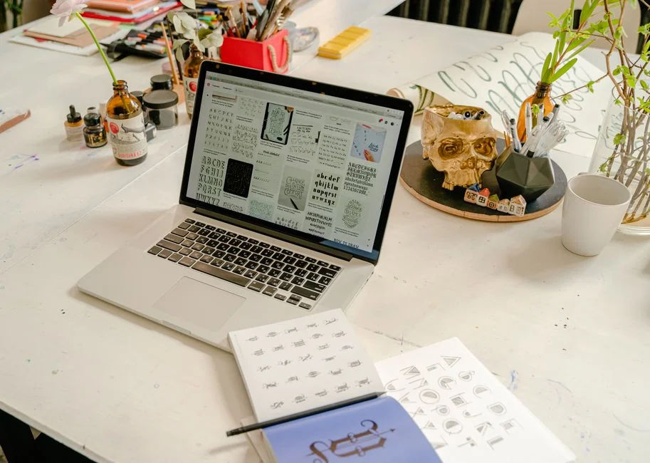Dual monitors on a desk, showcasing web design in a modern office setting.